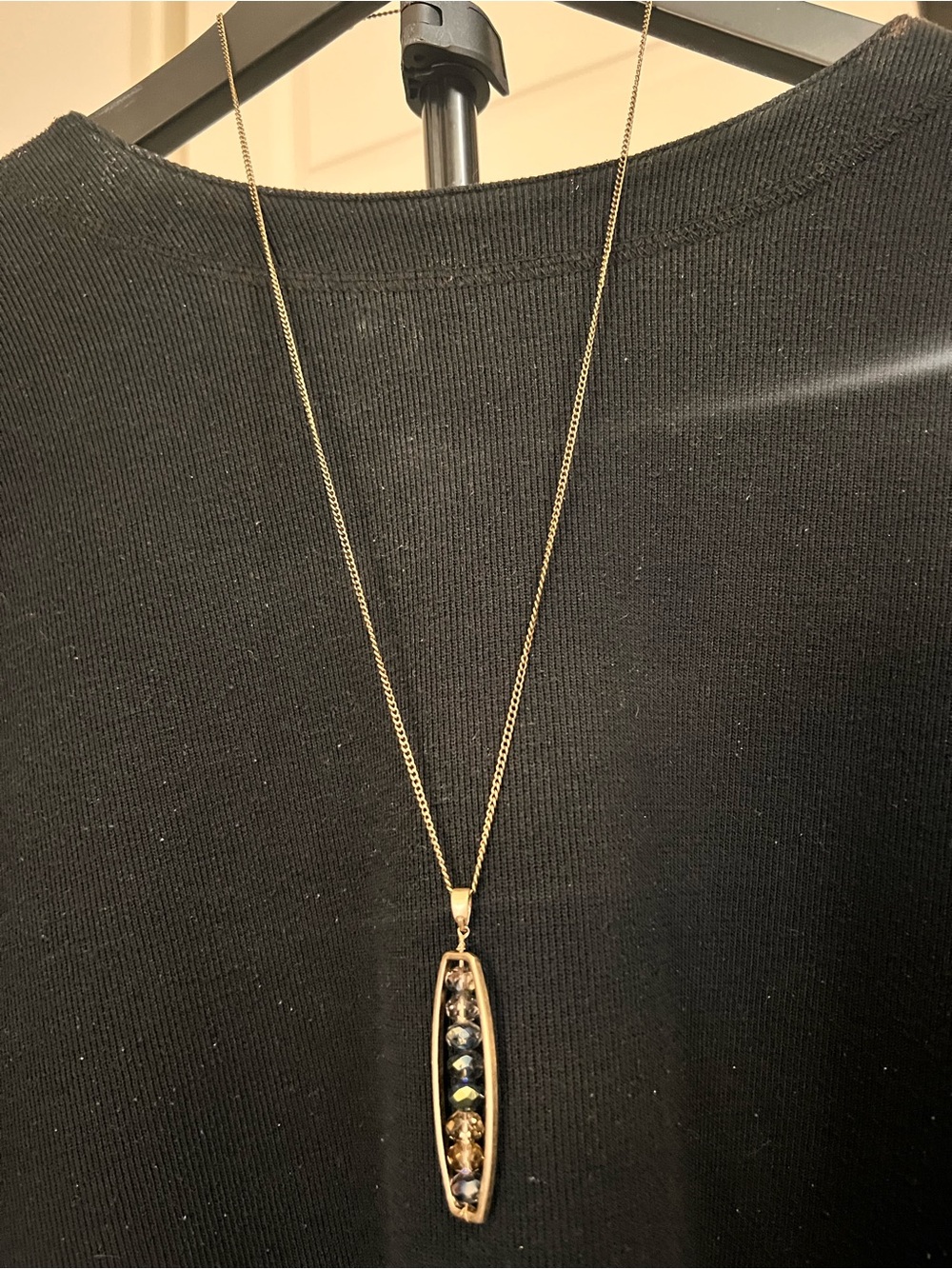 Gold-Tone necklace with multiple beads in an open pendant
